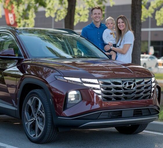Red Hyundai with happy customers-Hail Damage Repairs Downtown Garage & Auto Body